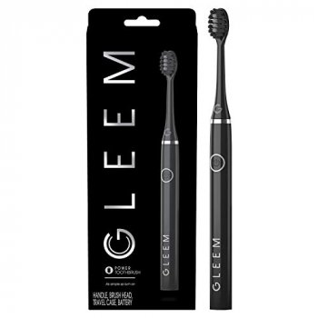Black Gleem toothbrush beside box